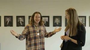 Een foto van presentator Pascal met een grote zware zilveren burgemeestersketting om zijn nek. Hij kijkt trots. Naast hem staat een blonde vrouw, Tjarda Struik, de burgemeester van Leiderdorp.