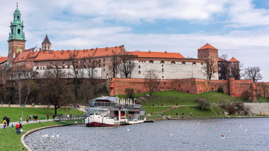 Een foto van een rivier met boot op de voorgrond, op de achtergrond zie je een burcht.