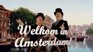 Foto van twee mannen in ouderwetse kleding en met hoge hoeden spreiden armen uit om je te verwelkomen in Amsterdam, met op de achtergrond de grachtengordel.
