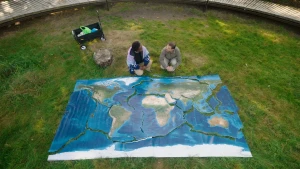 Foto van wereldkaart met breuklijnen, gelegen op een grasveld.