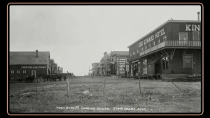 Een zwart-wit foto van de Main Street in Strathmore, ALberta, Canada, je ziet een hotel en enkele andere panden.