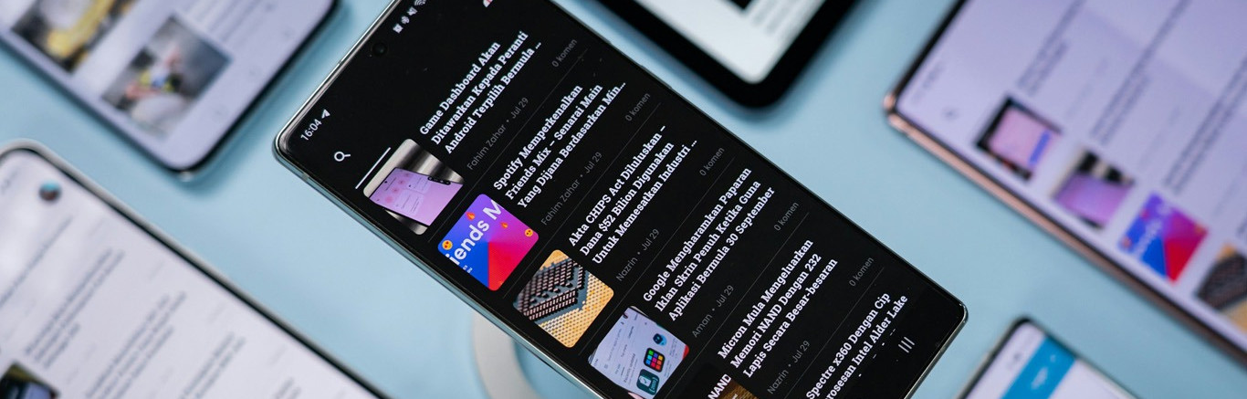 Foto van diagonaal liggende devices waarop nieuwsapps met headlines geopend zijn.