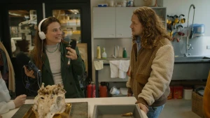 Foto van Klokhuispresentator Pascal met podcastmaker Sarah in een keuken waar een soort dierenschedel ligt.