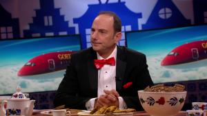 Thomas van Luyn kijkt naar de zijkant. Achter hem op de schermen is het vliegtuig van Sinterklaas te zien.