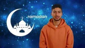 De presentator (man) staat voor een achtergrond van de nacht met het woord ramadan achter zich.