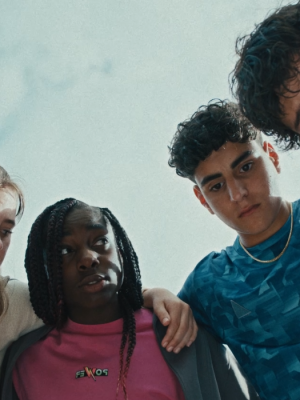 Een team staat in een kring met de armen om elkaars schouders, de foto is vanuit de kring genomen.