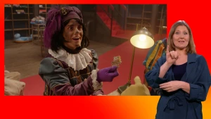 Piet staat met een puzzelstukje in de hand. De gebarentolk staat naast het scherm.