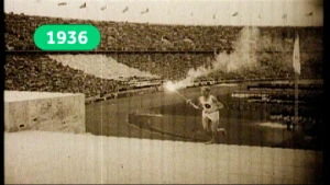 Zwartwitbeeld van atleet die rent met Olympische fakkel in een stadion in 1936.