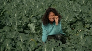 Presentatrice zit in een veld vol broccoli.