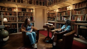 Twee mensen zitten in bruine stoelen in een bibliotheek.