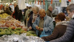 Foto van verschillende mensen rond een fruitkraam op de markt.