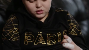 Een foto van Pablo, hij wijst met zijn ene hand de andere hand aan die helemaal in het verband zit.