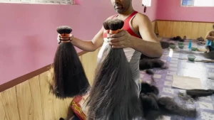 Een foto van een man die twee strengen haar op gang houdt.