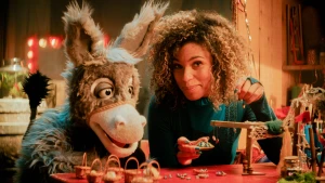 Een foto van de presentatrice en het ezeltje, ze zitten aan tafel.