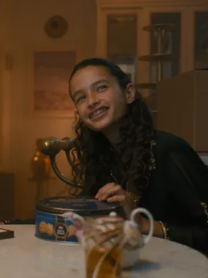 Een foto van een vrouw en een meisje aan een tafel, de vrouw heeft een hoofddoek om, ze kijken richting de camera.