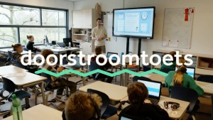 Foto van basisschoolklas met meester voor het digibord, in beeld staat het woord doorstroomtoets met groene golfjes eronder.