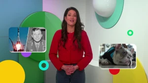 Presentator Milou in decor ochtendjournaal tussen afbeeldingen van Yuri Gagarin en een hondje op het vliegveld.