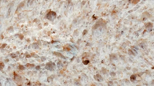 Foto van volkorenbrood van dichtbij, met luchtkamers en stukjes graankorrel.