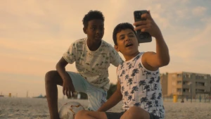 Foto van twee jongens die een selfie maken op het strand.