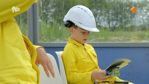 Foto van jongetje met bouwhelm die samen met Soy Kroon zit.