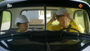 Foto van kind met bouwhelm die samen met Soy Kroon in een auto zit.