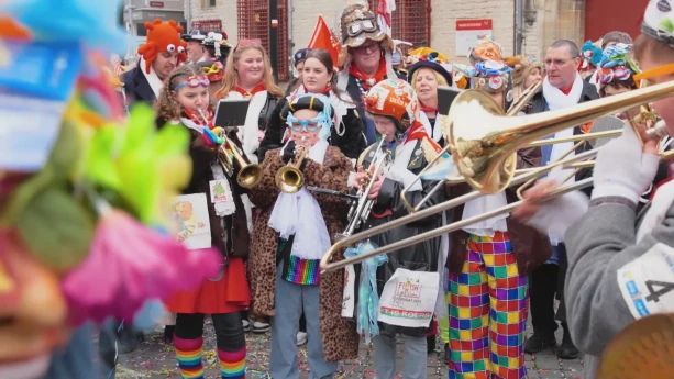 Foto van kinderen die muziekinstrumenten spelen in carnavalskleding.