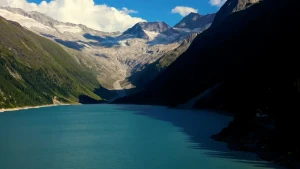Foto van een blauw stuwmeer in de Alpen, meer omringd door bergen.