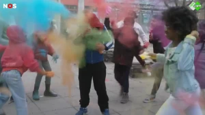 Kinderen gooien zakjes met gekleurd poeder over elkaar (Holi)