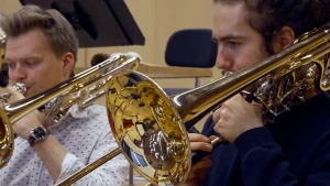 Foto van twee muzikanten die trombone spelen in het orkest.